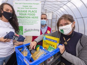Allison DeBlaire, left, co-founder of 519 Pursuit, Chris Hawkins of Lowe's and Jane Roy of the London Food Bank are encouraging donations to the food bank's Thanksgiving food drive.  (Mike Hensen/The London Free Press)