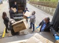 Lorrie Forbes and Brian Duivesteyn of Presstran help unload boxes of masks at St. Thomas-Elgin General Hospital. 
Presstran and Formet, both Magna International companies, donated 50,000 medical-grade masks to the hospital on Friday. (Mike Hensen/The London Free Press)