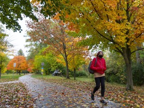 Roufa Therrien of London walks through a colourful Gibbons Park on the way to class at Western University in London, Ont. 
Photograph taken on Thursday October 15, 2020.  (Mike Hensen/The London Free Press)