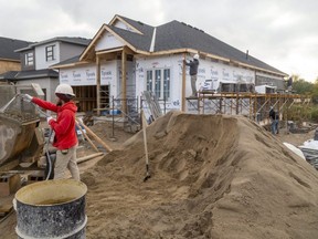 Matthew Senior mixes mortar as bricklayers work on an exterior wall of a home under construction on the west side of Ilderton north of London.  2020 is expected to be another record year for construction in Middlesex County as it continues to attract people from the GTA attracted by lower home prices. (Mike Hensen/The London Free Press)