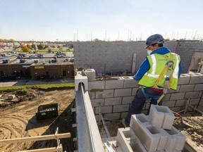 Rui Medeiros lays bricks on a new 65-unit affordable housing building being built on Clarke Road just north of Dundas Street in London. The building will be mostly one-bedroom apartments with some two-bedroom suites. Photograph taken on Wednesday October 28, 2020.  (Mike Hensen/The London Free Press)