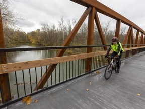 Jiri Svoboda rides his bike over the new bridge near Adelaide Street connecting sections of London's Thames Valley Trail Friday. "Honestly, I've been coming past here all summer waiting for this," said Svoboda, who has cycled 10,000 kms this year. 
 (Mike Hensen/The London Free Press)