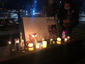 People hold a candlelight vigil in memory of Joyce Echaquan on September 29, 2020, near to Joliette Hospital, near Montreal, Quebec. - The recent death of indigenous woman Joyce Echaquan in a Quebec hospital after being berated and subjected to racist comments by a nurse sparked an outcry that has emboldened indigenous people across the nation to speak out against racism and share their own experiences with discrimination. (Photo by Anne-Sophie THILL / AFP)