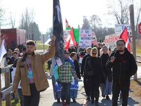 Around 200 anti-restrictions demonstrators marched from the St. Thomas Elgin Memorial Centre to Veterans Memorial Gardens on Saturday. (DALE CARRUTHERS, The London Free Press)