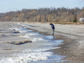 Andre Hubert searches for beach glass Wednesday at Port Stanley Beach in Port Stanley. He gives his finds to his daughter, who uses them to create works of art. (Derek Ruttan/The London Free Press)