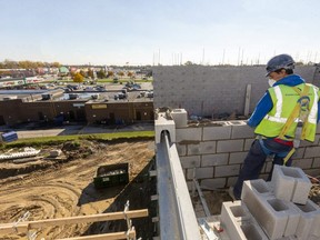 Rui Medeiros lays bricks on the new 65-unit affordable housing building going up on Clarke Road in London. (Mike Hensen/The London Free Press)