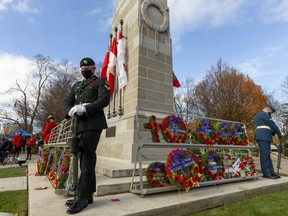 Cpl. Sheldon Fickling, centre, of the 4th Battalion of the Royal Canadian Regiment stands sentry at the Victoria Park cenotaph along with Royal Canadian Mounted Police Const. Mike Gibson and Royal Canadian Air Force Cpl. Jonathan Charrier, with Royal Canadian Navy sentry Sailor 2nd Class Kevin Ruchhin hidden by cenotaph during Remembrance Day ceremonies in London on Wednesday. (Mike Hensen/The London Free Press)