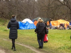 Misson Services workers Michelle Lollar and Justine Patry walk through the Wellington Valley encampment as they try to reach out to people there. (Mike Hensen/The London Free Press)