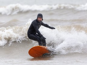 Andrew Wyton of Port Stanley cuts back against a wave as he surfs in Lake Erie off the small beach at the port town south of London.  Wyton, says he "moved here about a year ago for this." Mike Hensen/The London Free Press