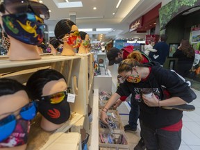 Jasmine Sadler and Wayne Edwards shop for masks at White Oaks Mall in London. Photograph taken on Sunday November 29, 2020. (Mike Hensen/The London Free Press)