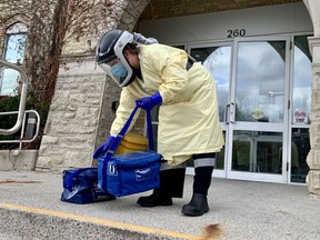 Jessica Robb, a member of the Perth County Paramedics' community outreach program, retrieves swabbing kits to test Cedarcroft Place staff Monday afternoon. (Cory Smith/The Beacon Herald)
