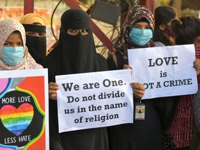 Activists belonging to various human and civil rights organisations hold placards during a demonstration condemning the decision of various Bharatiya Janata Party (BJP) led state governments in the country for the proposed passing of laws against "Love Jihad" in Bangalore on December 1, 2020. (Photo by Manjunath Kiran / AFP)