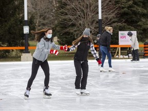 Natalie Conley, left, relearns  to skate at Victoria Park with help from friend Isla St. John. (Derek Ruttan/The London Free Press)