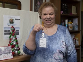 Ruth-Anne Calhoun displays a new Christmas ornament to replace the one honouring her deceased son which was stolen from the Angel Tree in Victoria Park. (Derek Ruttan/The London Free Press)