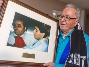 Joe Callipari holds a photo proving he met soccer legend Diego Maradona in Italy in 1990. Callipari ran into the Argentine soccer icon, who died last week at 60, in a Milan hotel elevator before Argentina's World Cup opener that year.  (Mike Hensen/The London Free Press)