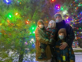 Jesse Foster and Brooke Thompson with their children Forest, 3, and Henry, 8, were the family chosen to symbolically turn on the lights in Victoria Park on Thursday. Foster is a personal support worker at London Health Sciences Centre's Victoria Hospital. (Mike Hensen/The London Free Press)