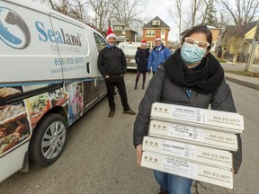 Marcus Paton and Amy and Sean Nother of Sealand Quality Foods deliver $1,500 worth of frozen food to Stacy Wilson, program supervisor for Rotholme Family Shelter, in London. (Mike Hensen/The London Free Press)
