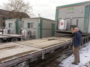 Mel Surgeson guides a truck delivering a trailer to 652 Elizabeth St., near Carling Heights Optimist community centre, in London Friday. The trailer, one of seven due by Saturday, will become part of a temporary city winter shelter complex for the homeless. (Mike Hensen/The London Free Press)