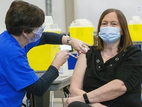 Karen Dann, an administrator at a local long-term care home, was given the very first COVID-19 vaccine in London on Wednesday, December 23, 2020. It was administered by public health nurse Tracy Benedict at the city's field hospital, set up at Western Fair. (Mike Hensen/The London Free Press)