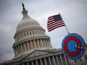 Supporters of U.S. President Donald Trump fly a U.S. flag with a symbol from the QAnon conspiracy theory group as they gather outside the U.S. Capitol in Washington, D.C., on Wednesday as Congress met to ratify president-elect Joe Biden's Electoral College win over Trump. A large number protesters stormed the Capitol building as the meeting got underway. (Win McNamee/Getty Images)