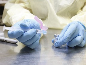 A UHN (University Health Network) health-care technician preparse syringes of the Pfizer-BioNTech COVID-19 on January 7, 2021.