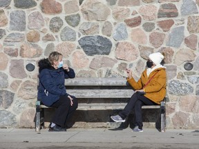 Corrie Bendall (left) and Susan Annett take a break from their weekly Wednesday walk to sit and chat in the sunshine at Springbank Park in London on Wednesday January 13, 2021. "Thank God for this beautiful day," said Bendall. (Derek Ruttan/The London Free Press)