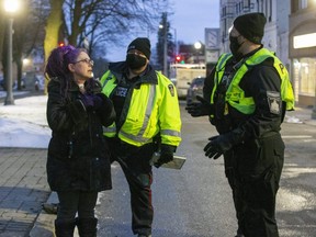 Police advise Julie Corneman to have protesters split into groups of five per COVID-19 rules as Project Phoenix, a protest of school closings and Ontario lockdown orders organized by Phoenix Scott, 13, takes to Woodstock’s Museum Square Thursday. (Derek Ruttan/The London Free Press)