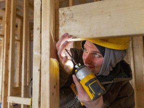 Ethan McIlroy of Hayhoe Homes screws in a brace between studs in a new semi-detached home they're building in the south end of St. Thomas.  (Mike Hensen/The London Free Press)