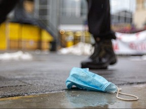 A discarded medical mask sits rumpled at the side of London's flex street.  Mike Hensen/The London Free Press