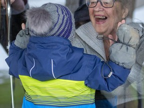 Yvonne Peckham greets Hudson Dutot, 2, as they meet through the front door as the neighbours continue to be close throughout the lockdown in London. (Mike Hensen/The London Free Press)