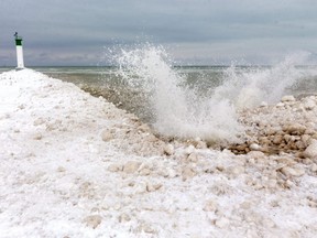 Waves splash against the mounds of ice near the pier in Grand Bend on Tuesday, Jan. 26, 2021.  Dramatically reduced ice cover on the Great Lakes this winter is a concern, not just for ice fishers and skaters. (Mike Hensen/The London Free Press)