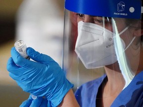 A nurse prepares a syringe with the COVID-19 vaccine.  (File Photo)