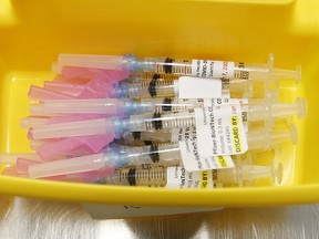 Health-care technicians prepare syringes of the Pfizer-BioNTech COVID-19 vaccine for front-line health-care workers at a UHN clinic at the MaRS building on January 7, 2021.