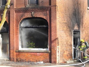 Firefighters work to douse a hot spot after a fire caused significant damage to a building on Victoria Street in downtown Thamesville on Wednesday. Ellwood Shreve/Postmedia Network