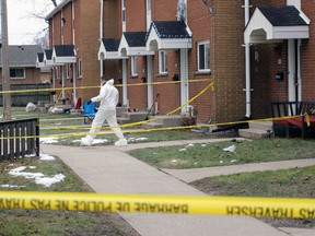 Police investigate a suspected homicide at a Confederation Street townhouse complex Sunday in Sarnia. (Terry Bridge/Postmedia Network)