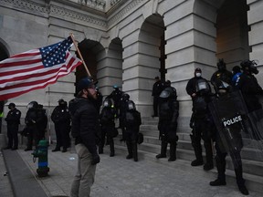 A Trump supporter confronts police and security forces at the US Capitol in Washington, DC, on January 6, 2021. - Demonstrators breeched security and entered the Capitol as Congress debated the a 2020 presidential election Electoral Vote Certification. (Photo by ANDREW CABALLERO-REYNOLDS / AFP)