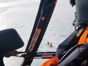 A helicopter crew from the U.S. Coast Guard's Air Station Detroit rescues a stranded angler on Lake St. Clair near Mitchell's Bay in Chatham-Kent on Saturday, Jan. 30, 2021. (Lt. Drew Caudill Photo/Courtesy of U.S. Coast Guard)