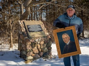 Jim Crane is outraged after land near Iona Station originally donated by his late great uncle, James Crane, was sold off by the local conservation authority. He’s pictured next to a memorial cairn on the land, and holding an oil painting of James Crane, a doctor, teacher and conservationist who planted trees on the seven-acre property in the 1930s. (Max Martin/THE LONDON FREE PRESS)