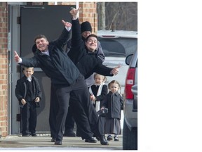 Parishioners ham it up for the media after an indoor Sunday service at the Church of God in Aylmer on Sunday that breached Ontario rules designed to slow COVID-19's spread. Derek Ruttan/The London Free Press