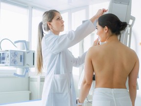 A woman undergoes a mammogram screening procedure.