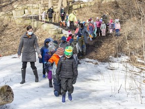 Early childhood educator Val Williams guides kindergarten pupils from St. Mark elementary school during an outdoor education class in the ravine behind the school in London on Wednesday, March 10, 2021. (Derek Ruttan/The London Free Press)