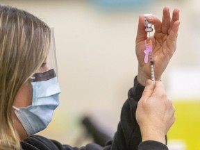 Jill Seara, a public health nurse loads a syringe with the Pfiizer COVID-19 vaccine at the Caradoc Community Centre in Mt. Brydges.  (Mike Hensen/The London Free Press)