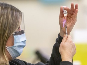 Jill Seara, a public health nurse, loads a syringe with the Pfiizer COVID-19 vaccine at the Caradoc Community Centre in Mt. Brydges.  (Mike Hensen/The London Free Press)