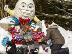 Sybil Kyba serves up BeaverTails in Storybook Gardens under the watchful gaze of Humpty Dumpty. Kyba said her daughters, Calla Bender, 6 ,and Amber Bender, 4, "were more interested in them (BeaverTails) than the skating." Photograph taken on Sunday February 21, 2021.  (Mike Hensen/The London Free Press)