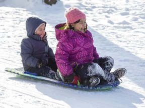 Sara Azemi, 8, and her brother Elyas, 3, toboggan at Springbank Park Sunday Feb. 14, 2021.  (Derek Ruttan/The London Free Press)