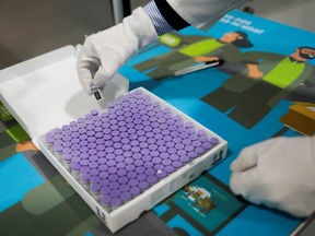 A worker of Bidafarma shows Pfizer-BioNTech COVID-19 vaccines at the Spanish pharmaceutical distributor 'Bidafarma' Granada warehouse, in Santa Fe, Spain, Monday, Feb. 1, 2021.