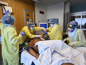 Health-care workers turn a COVID-19 patient in the ICU who is intubated and on a ventilator from his back to his stomach at the Humber River Hospital during the COVID-19 pandemic in Toronto on Dec. 9, 2020.
