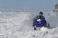 A snowmobiler cuts through snow while riding on the surface of Lake St. Clair near the Belle River pier in January 2015.