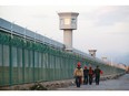 Workers walk by the perimeter fence of what is officially known as a vocational skills education centre in Dabancheng in Xinjiang Uyghur Autonomous Region, China Sept. 4, 2018. Repression of Muslim minorities by the Beijing government has been likened to genocide.