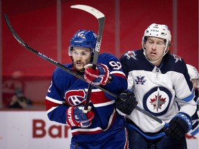 Canadiens' Jonathan Drouin, left, and Jets' Tucker Poolman battle for position Thursday night at the Bell Centre. Drouin had a strong game for Montreal, registering two assists, four hits and a blocked shot.